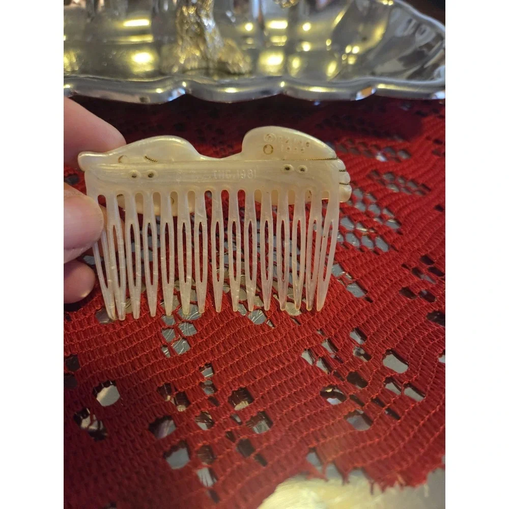 T.Z. Inc. 1981 vintage hair comb is made of faux mother-of-pearl cellulose...